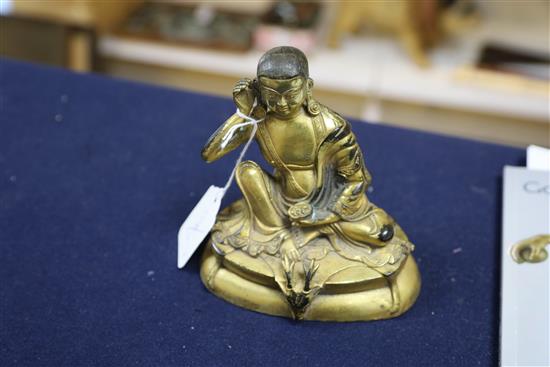 A Sino-Tibetan gilt bronze seated figure of Milarepa, H. 14cm